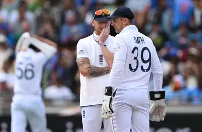 Ben Stokes and Jamie Smith confer during a break in play.
